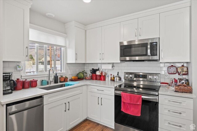 kitchen featuring a sink, light countertops, white cabinetry, stainless steel appliances, and decorative backsplash