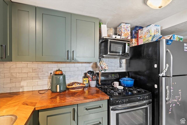 kitchen featuring wood counters, backsplash, green cabinetry, and stainless steel appliances
