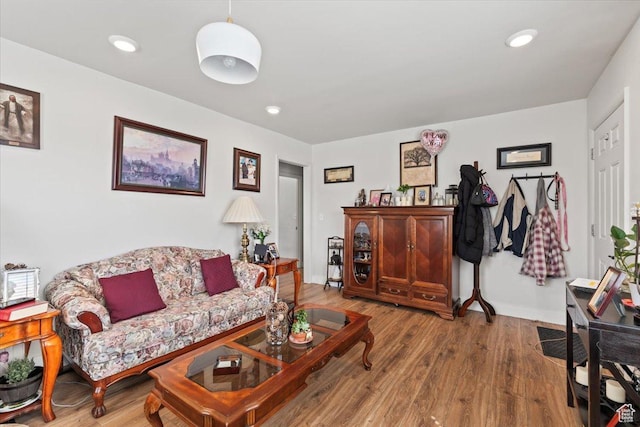 living area with baseboards, recessed lighting, and wood finished floors