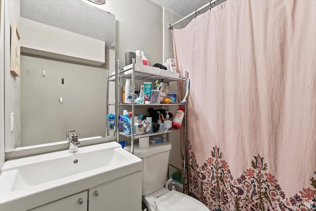 bathroom with vanity, a textured ceiling, a shower with curtain, and toilet