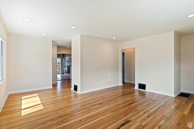 unfurnished room with recessed lighting, visible vents, light wood-type flooring, and baseboards