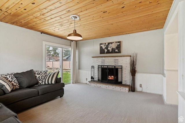 living area with wooden ceiling, carpet flooring, a fireplace, and a wainscoted wall