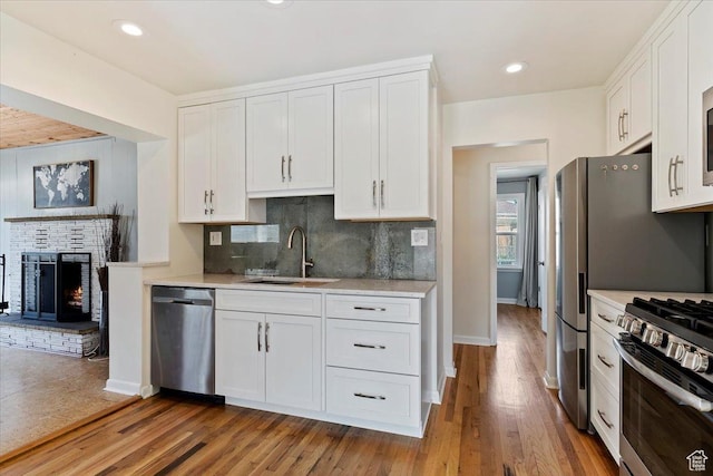 kitchen featuring a sink, light countertops, white cabinets, and appliances with stainless steel finishes