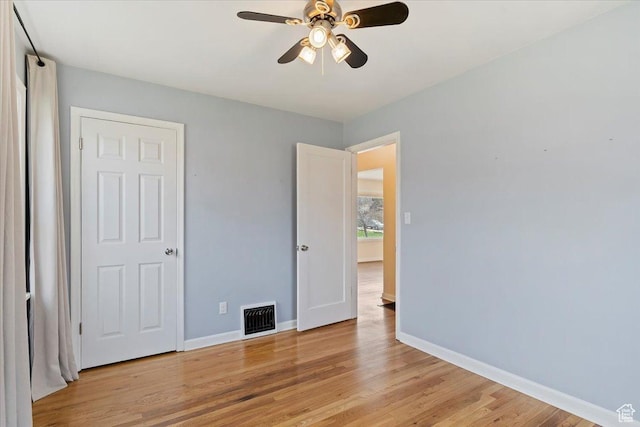 unfurnished bedroom with visible vents, light wood-type flooring, baseboards, and a ceiling fan