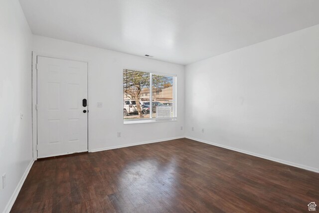 entrance foyer featuring dark wood-type flooring, visible vents, and baseboards