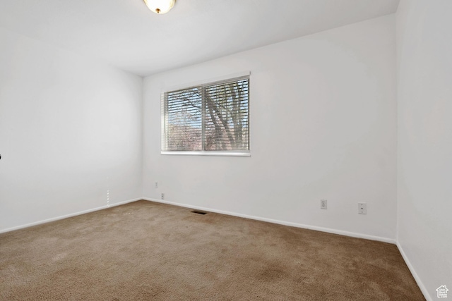 empty room featuring baseboards, visible vents, and carpet floors
