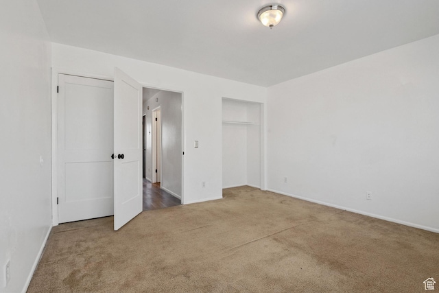 unfurnished bedroom with multiple closets, carpet, and baseboards