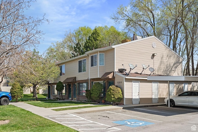 view of front of house with covered and uncovered parking, brick siding, a chimney, and a front lawn