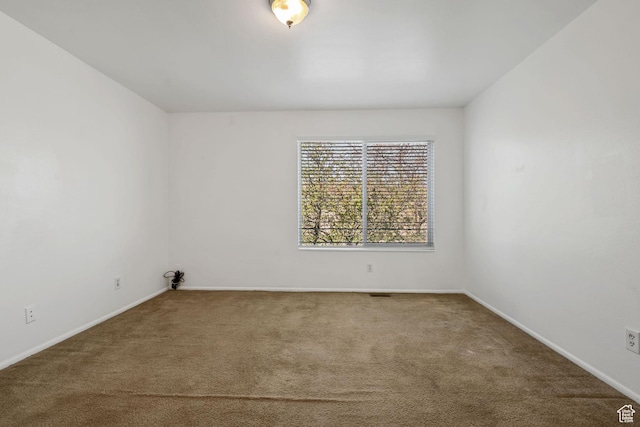 unfurnished room with carpet flooring and baseboards