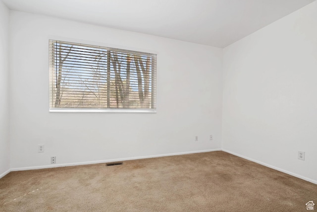 unfurnished room featuring baseboards, visible vents, and carpet floors