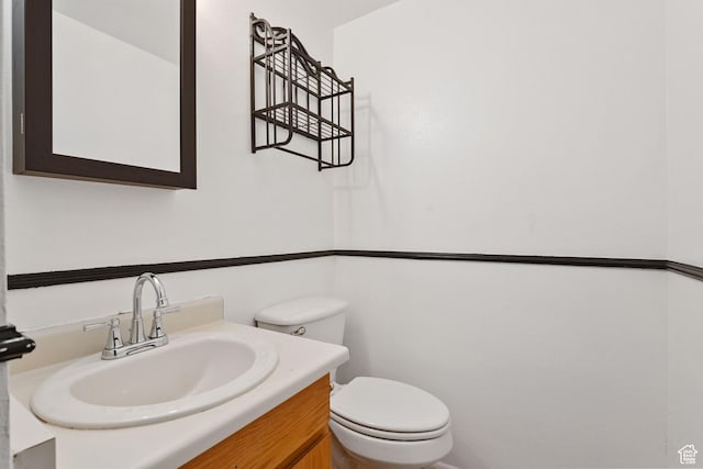 half bathroom featuring toilet and vanity