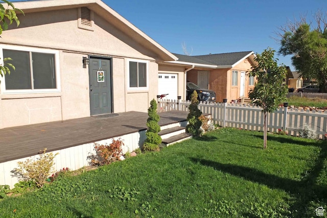1653 N Cedar Blvd, Cedar City, UT 84721 - view of front facade with stucco siding, a front lawn, an attached garage, a wooden deck, and fence