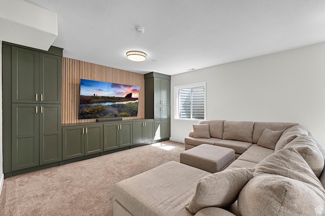 living area with baseboards, an accent wall, and light carpet