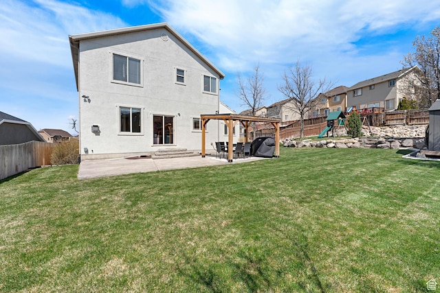 back of house with a patio area, a fenced backyard, a playground, and a yard