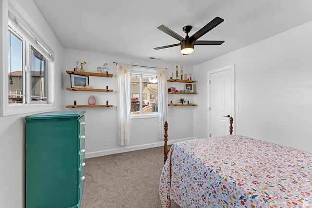 carpeted bedroom featuring baseboards, a ceiling fan, and visible vents