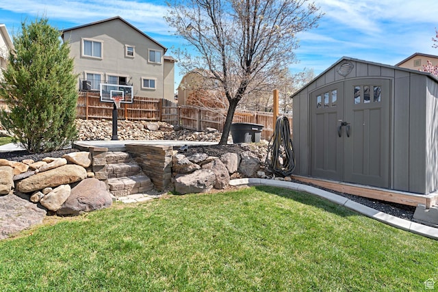 view of yard featuring fence, an outdoor structure, and a storage unit