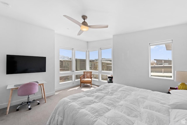 carpeted bedroom with multiple windows, baseboards, and a ceiling fan