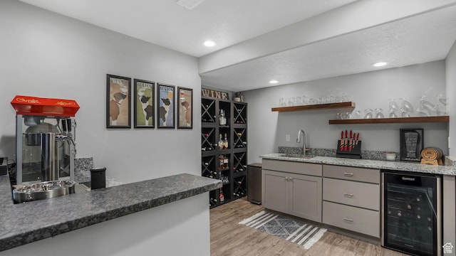 bar featuring wet bar, recessed lighting, wine cooler, light wood finished floors, and a sink