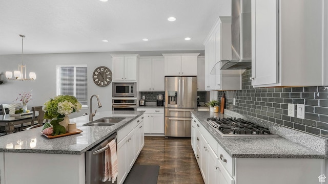 kitchen featuring wall chimney exhaust hood, white cabinets, a sink, stainless steel appliances, and dark wood-style floors