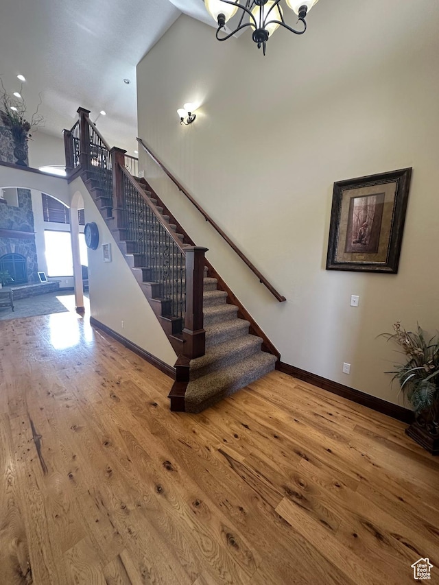 1234 S Parkway Blvd E Unit 725, Saratoga Springs, UT 84045 - stairway with baseboards, arched walkways, an inviting chandelier, and wood finished floors