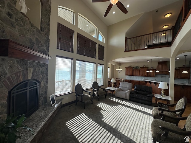 1234 S Parkway Blvd E Unit 725, Saratoga Springs, UT 84045 - carpeted living area featuring baseboards, a stone fireplace, and a ceiling fan