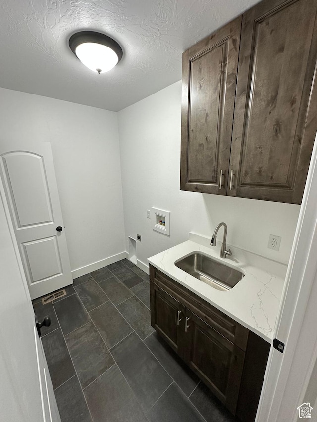 1234 S Parkway Blvd E Unit 725, Saratoga Springs, UT 84045 - laundry room featuring baseboards, a textured ceiling, hookup for a washing machine, cabinet space, and a sink
