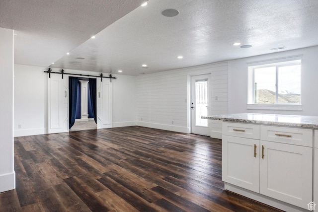 159 E 625 S, Mantua, UT 84324 - unfurnished living room with a barn door, a textured ceiling, dark wood finished floors, baseboards, and recessed lighting