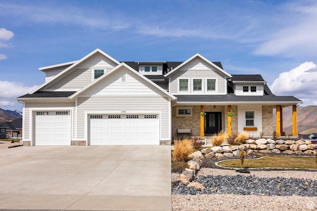159 E 625 S, Mantua, UT 84324 - view of front of house featuring stone siding, covered porch, driveway, and an attached garage