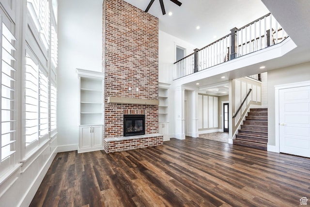 159 E 625 S, Mantua, UT 84324 - unfurnished living room with a towering ceiling, dark wood-type flooring, a fireplace, baseboards, and a ceiling fan