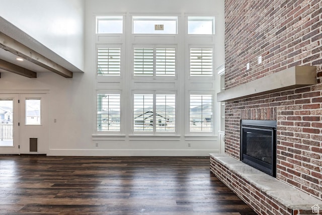 159 E 625 S, Mantua, UT 84324 - unfurnished living room featuring a towering ceiling, dark wood-style floors, baseboards, plenty of natural light, and a fireplace