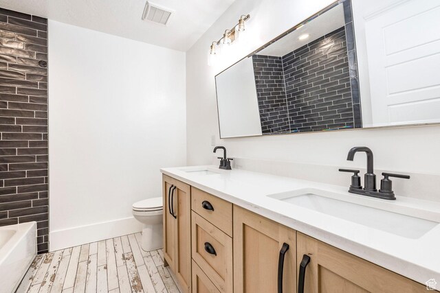 159 E 625 S, Mantua, UT 84324 - full bathroom featuring wood finished floors, toilet, a tub to relax in, double vanity, and baseboards