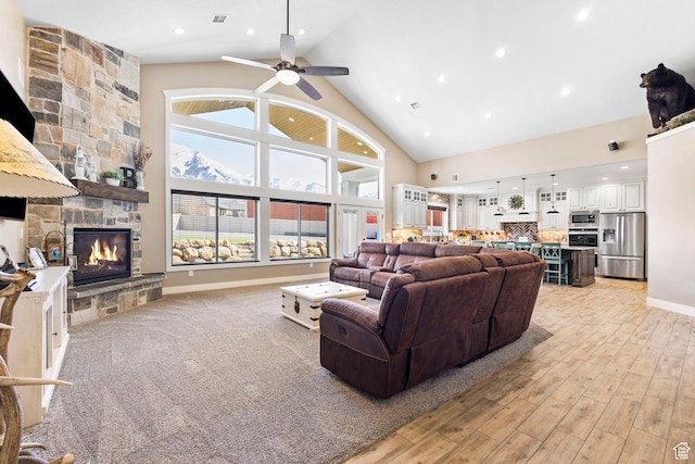 1125 S 400 E, Salem, UT 84653 - living area with baseboards, light wood-type flooring, a stone fireplace, a ceiling fan, and high vaulted ceiling