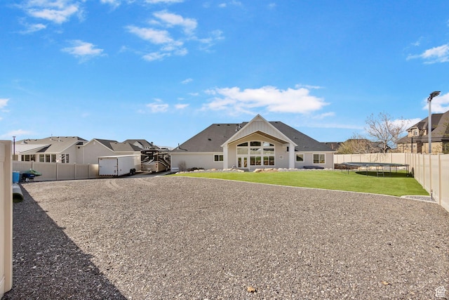 1125 S 400 E, Salem, UT 84653 - rear view of house with a trampoline, a fenced backyard, a residential view, and a yard
