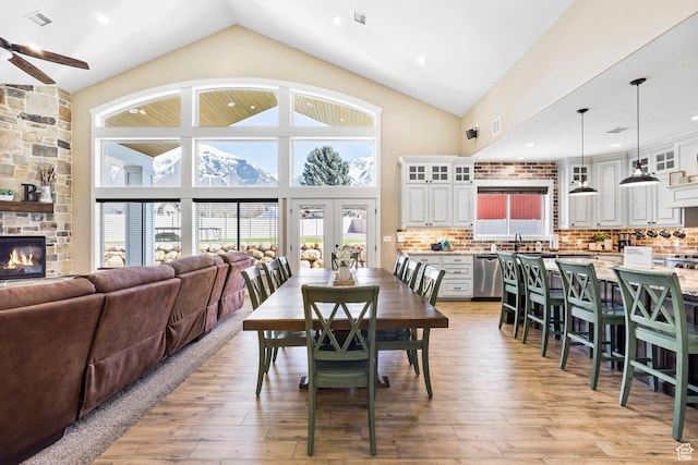 1125 S 400 E, Salem, UT 84653 - dining room featuring visible vents, a ceiling fan, a fireplace, light wood finished floors, and high vaulted ceiling