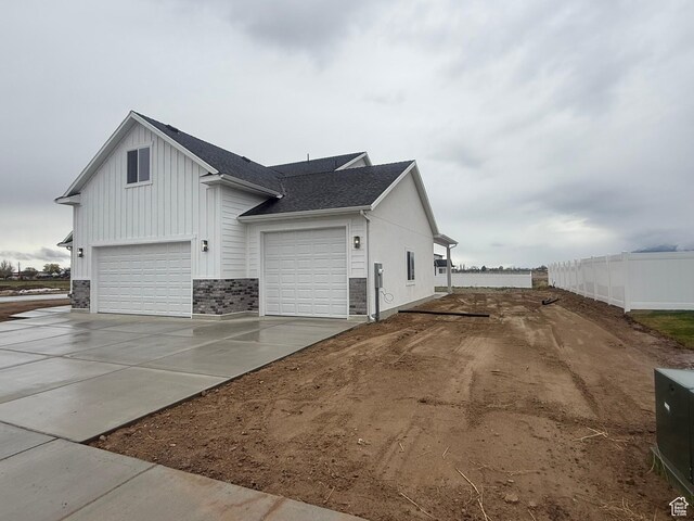 3758 W Alder Ct, Taylor, UT 84401 - view of home's exterior with board and batten siding, a shingled roof, fence, and concrete driveway
