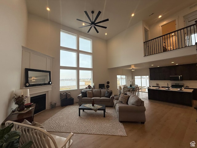 3758 W Alder Ct, Taylor, UT 84401 - living room with a fireplace, a high ceiling, light wood finished floors, and a wealth of natural light