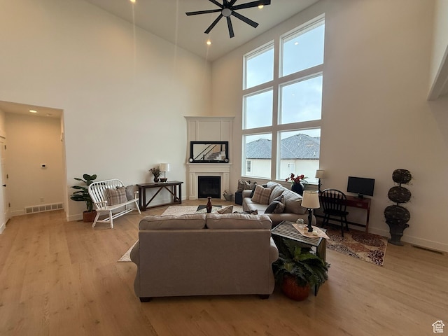 3758 W Alder Ct, Taylor, UT 84401 - living room featuring visible vents, baseboards, a high ceiling, ceiling fan, and light wood-type flooring