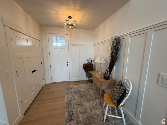 3758 W Alder Ct, Taylor, UT 84401 - entrance foyer featuring light wood-style floors, a decorative wall, and a wainscoted wall