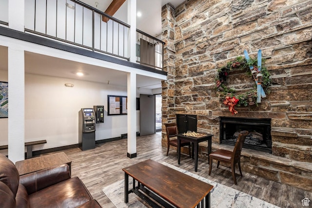 1940 Prospector Ave Unit 101, Park City, UT 84060 - living area featuring a stone fireplace, a high ceiling, wood finished floors, and baseboards