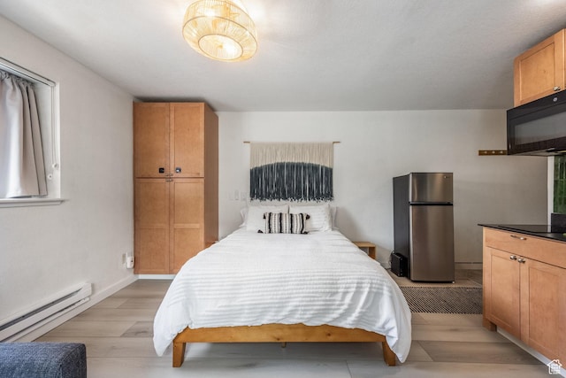 1940 Prospector Ave Unit 101, Park City, UT 84060 - bedroom with light wood-style flooring, a baseboard radiator, freestanding refrigerator, and baseboards