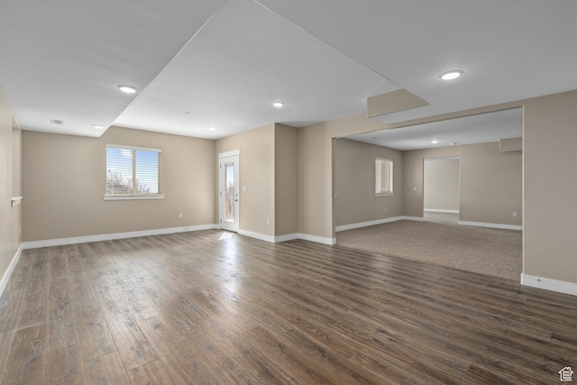 empty room with wood finished floors, baseboards, and recessed lighting