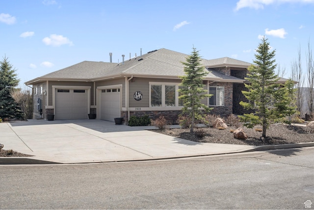 view of front of house featuring concrete driveway, roof with shingles, stone siding, and an attached garage