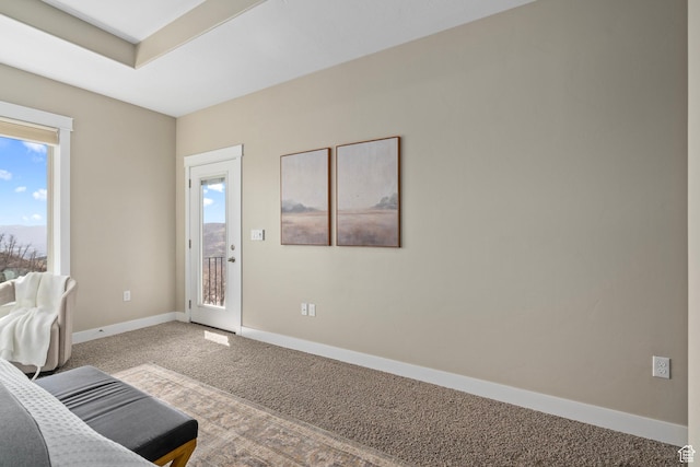 unfurnished room featuring baseboards, plenty of natural light, and carpet