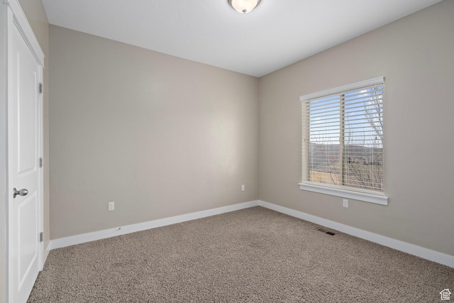 carpeted empty room featuring visible vents and baseboards