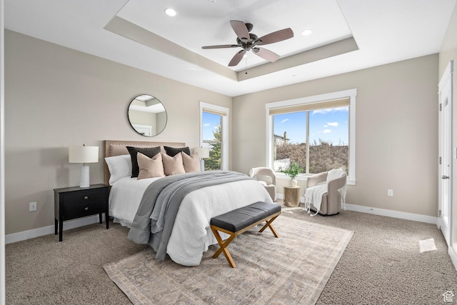 bedroom with a tray ceiling and baseboards