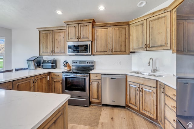 4071 S Sandpiper Ln, Saratoga Springs, UT 84045 - kitchen featuring light wood-style flooring, recessed lighting, appliances with stainless steel finishes, a sink, and brown cabinets