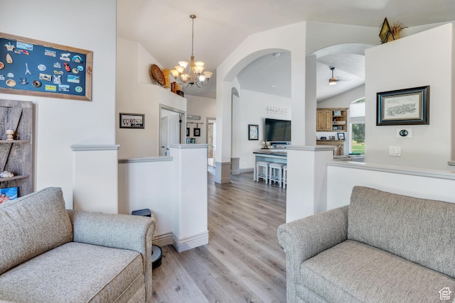 4071 S Sandpiper Ln, Saratoga Springs, UT 84045 - living area with light wood-type flooring, ceiling fan with notable chandelier, vaulted ceiling, and arched walkways