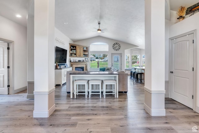 4071 S Sandpiper Ln, Saratoga Springs, UT 84045 - kitchen featuring baseboards, ceiling fan, a fireplace, light wood finished floors, and lofted ceiling