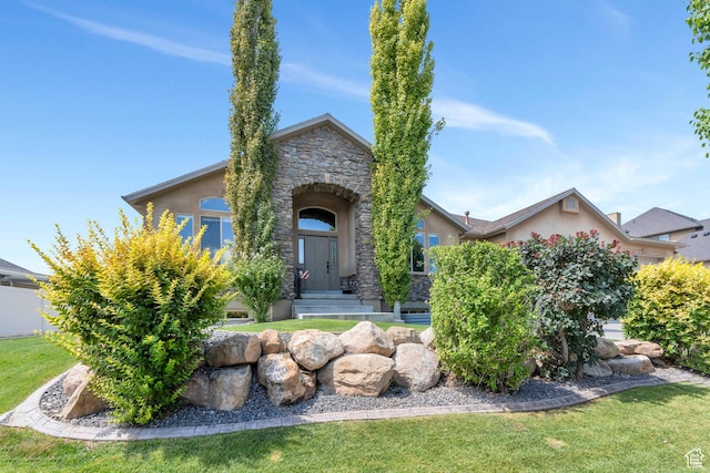 4071 S Sandpiper Ln, Saratoga Springs, UT 84045 - view of front facade with a front lawn, stone siding, and stucco siding