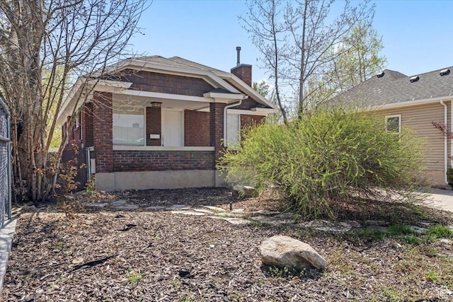 exterior space featuring a chimney and brick siding